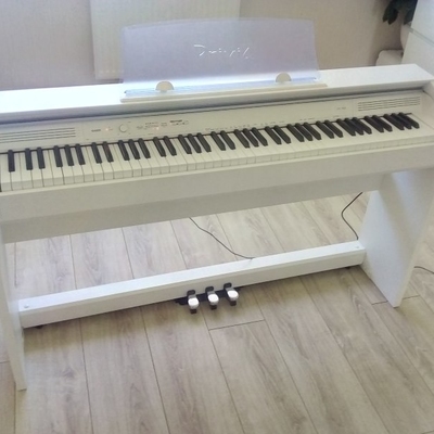 Белое пианино стоит посреди комнаты