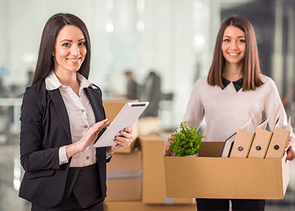 Сотрудницы офиса улыбаются с вещами в руках